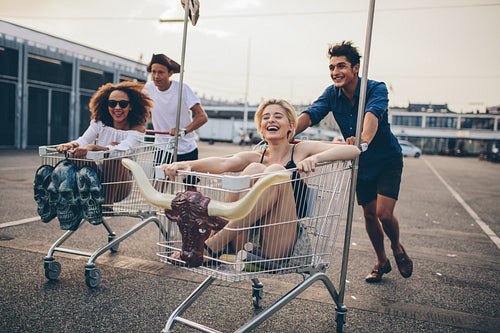 Young people racing with shopping trolleys