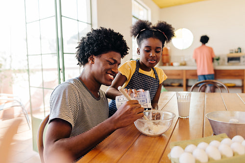 Family baking time: Afro-haired Brazilian siblings prepare a semolina cake