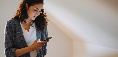 Woman at home texting on her phone