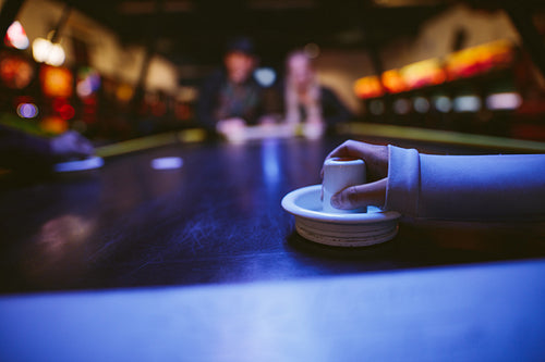 Young people playing air hockey