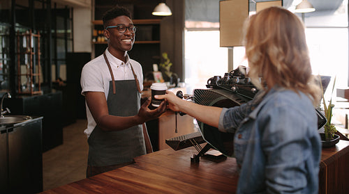 Barista serving customers inside a coffee shop