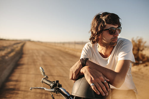 Man with bike standing on rural road