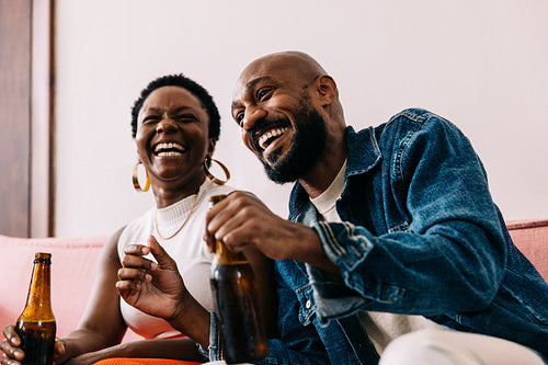 Friends laughing and enjoying drinks in a casual and stylish setting