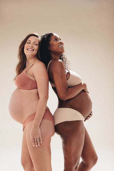 Pregnant friends wearing lingerie with confidence in an antenatal studio shoot