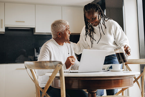 Mature woman bringing her working husband some coffee