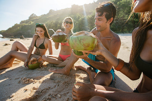 Friends enjoying beach vacation with coconuts