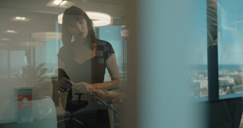 Business colleagues brainstorming together at a glass wall