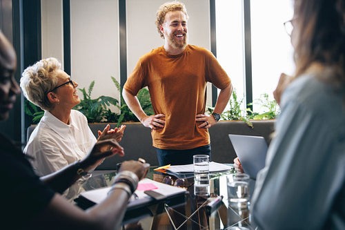 Young business man getting applauded by his team for his hard work and dedication