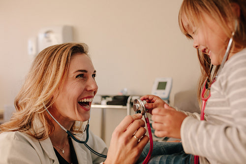 Friendly pediatrician with girl patient at clinic