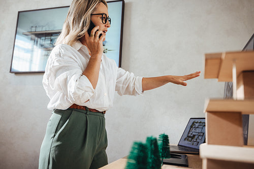 Young professional woman discussing architectural models in a modern studio