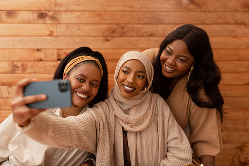 Diverse female friends taking a selfie together in a restaurant