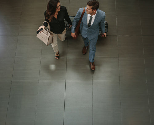 Business people walking through a hallway with luggage