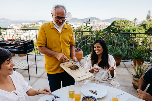 Family enjoying a sunny day with a traditional Brazilian churrasco gathering