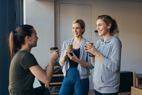 Fitness women drinking coffee after workout in a gym