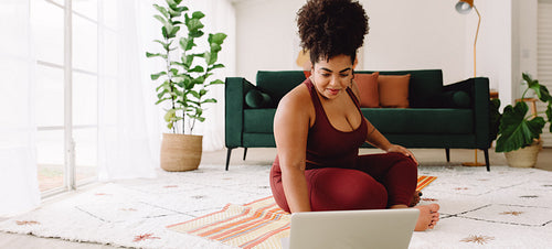 Fitness woman using laptop during workout at home