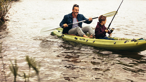 Father and son enjoying fishing in the lake