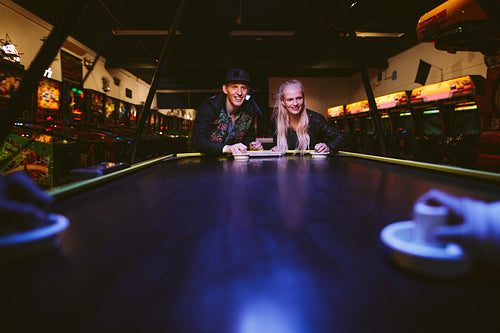 Friends playing a game of air hockey