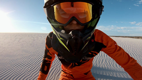 Fast cross country athlete riding a dirt bike in a desert