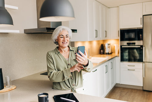 Cheerful senior woman taking a video call at home