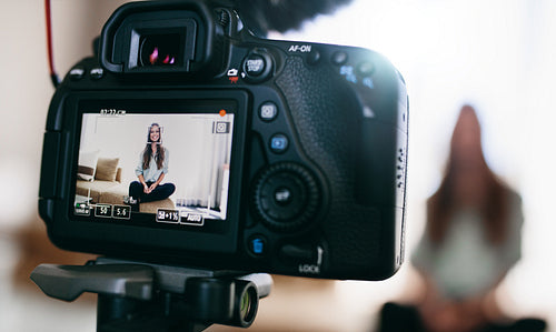 Young female vlogger on camera screen.