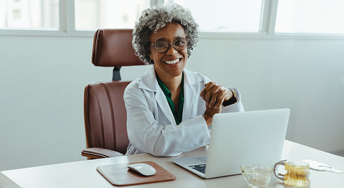Smiling dentist working at desk in professional office