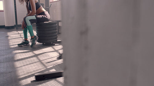 Female athlete taking rest after exercising at gym