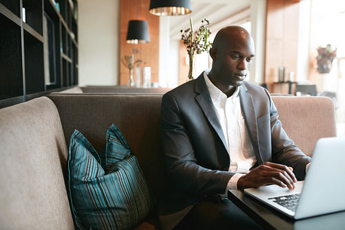 Young man sitting at cafe working on laptop