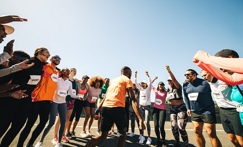 Energetic team leader hyping up members before a run