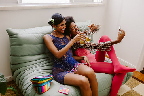 Friends celebrating at home on a sofa