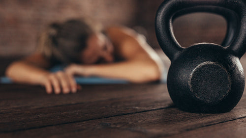 Cross training gym with woman resting after workout