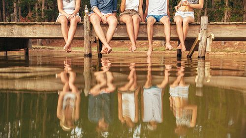 Young people sitting on the edge of a pier