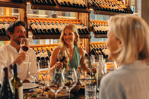 Adults wine tasting in a luxury setting with wine bottles and social atmosphere