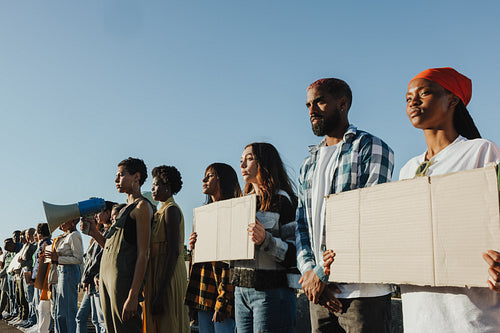 Diverse group of people standing together holding signs during a peaceful protest