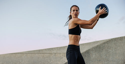 Athletic woman doing fitness training with a medicine ball