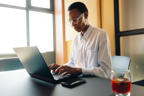 Professional woman working independently in a modern office environment using her laptop