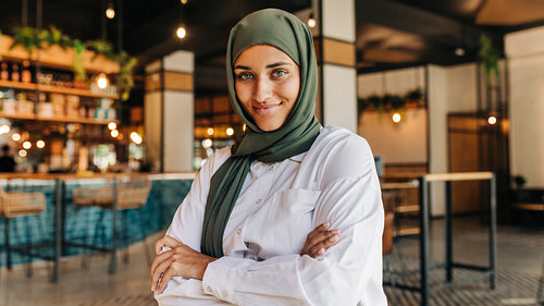 Cheerful Muslim woman looking at the camera in a cafe