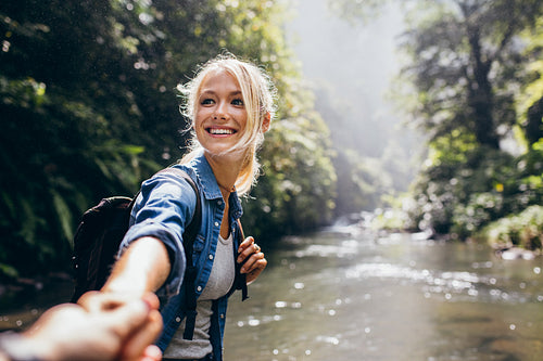 Hiker woman holding man's hand on a nature hike