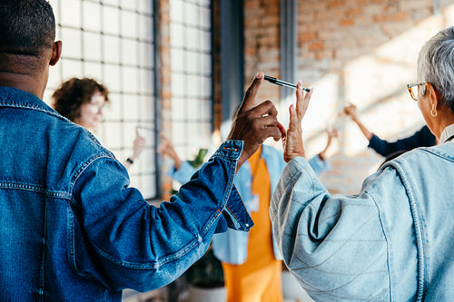 Group of adults in a circle participating in a trust game during an office session