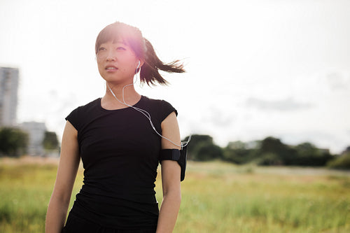Young woman in sportswear standing outdoors in city park
