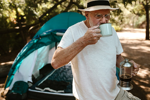 Senior man having coffee at campsite