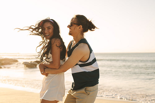 Playful young couple on beach vacation