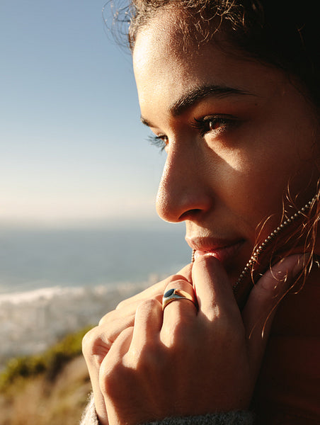 Beautiful woman on mountain looking at sea on winter day