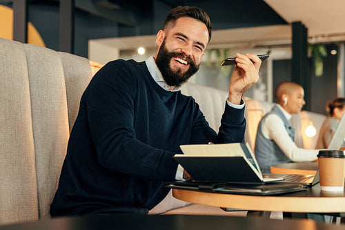 Smiling businessman taking a phone call in a co-working space