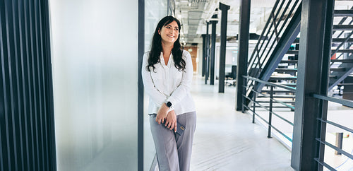 Businesswoman smiling while standing in a creative workplace