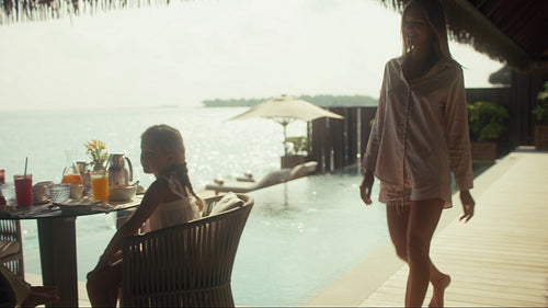 Happy family enjoying a relaxing breakfast overlooking the beautiful ocean at a tropical resort