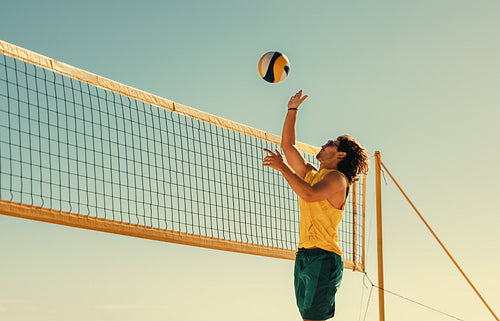 Mid-air volleyball jump by young australian athlete at coastal beach during summer games