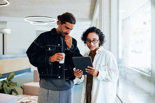 Two business people review tablet in office