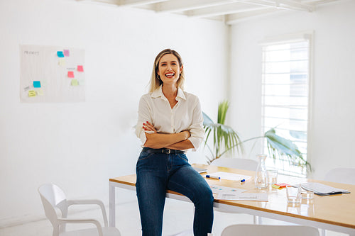 Creative businesswoman smiling cheerfully in a meeting room