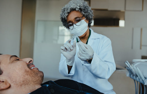 Dental aligner consultation with woman orthodontics specialist and male patient in clinic