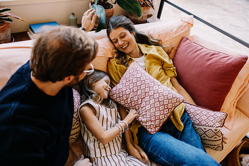 Family moment on sofa with cushions and laughter